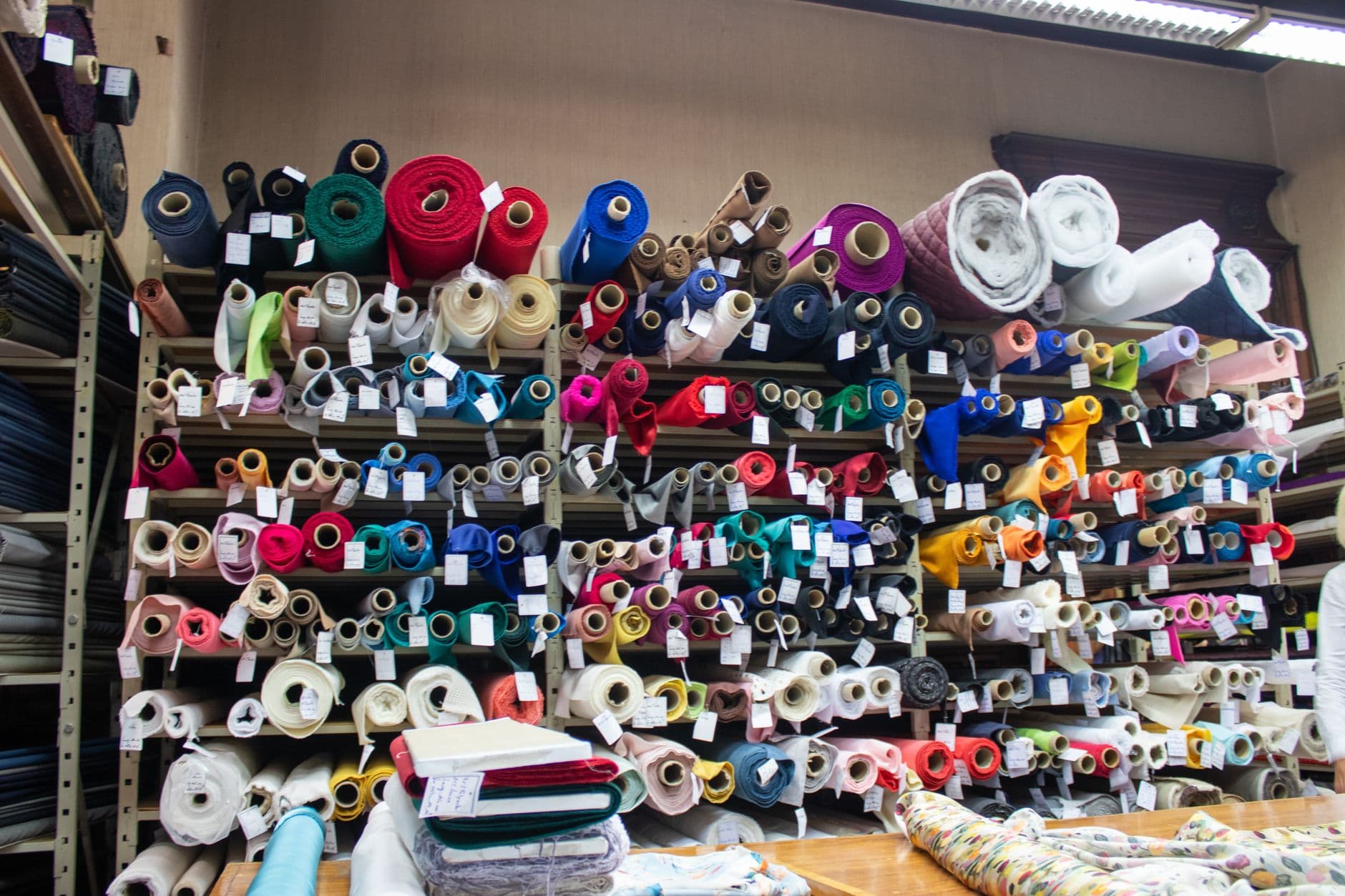 Shelves stacked with rolls of fabric in every color